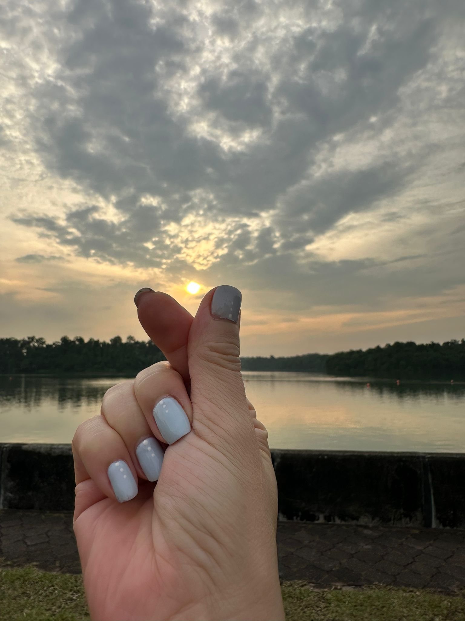 Pastel grey manicure with accent nail at sunset by the lake – Moon Nail Spa Singapore.
